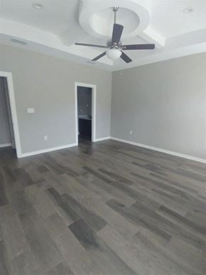 Brownsville house for rent - a living room with wood floors and a ceiling fan