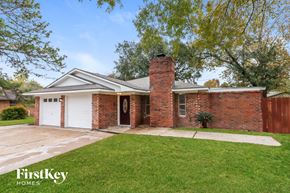 Baytown house for rent - a brick house with a brick chimney and a white garage door
