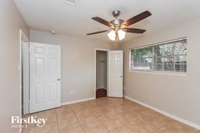 Baytown house for rent - a living room with a ceiling fan and a door to a closet