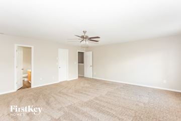Charlotte house for rent - a spacious living room with carpet and a ceiling fan