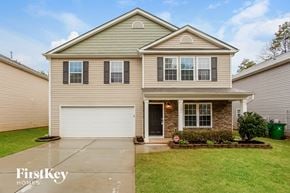 Charlotte house for rent - a beige house with a white garage door