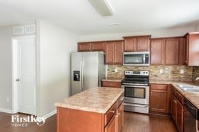 Charlotte house for rent - a kitchen with wooden cabinets and stainless steel appliances