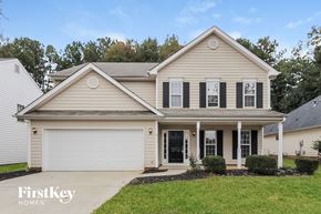Charlotte house for rent - a beige house with black shutters and a lawn
