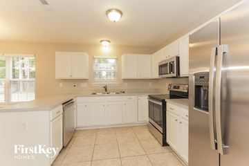 Charlotte house for rent - a kitchen with white cabinets and stainless steel appliances