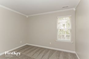 Charlotte house for rent - a bedroom with a carpeted floor and a window