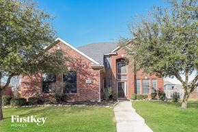 Rowlett house for rent - A brick house with a white door and windows.