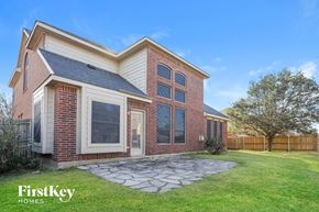 Rowlett house for rent - A brick house with a stone walkway in front.
