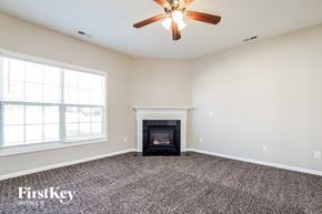 Holly Springs house for rent - a living room with a fireplace and a ceiling fan