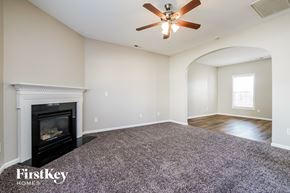 Holly Springs house for rent - a living room with a fireplace and a ceiling fan