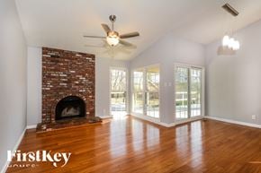 Ballwin house for rent - A living room with a brick fireplace and wood floors.