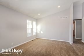 Ballwin house for rent - A spacious room with a carpeted floor and a window letting in natural light.