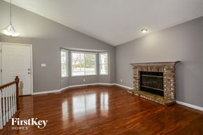 Lake St Louis house for rent - the living room of a house with a fireplace and wooden floors