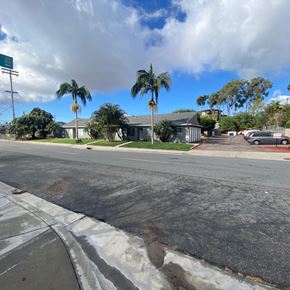 National City apartment for rent - A street with a sidewalk and a few palm trees.