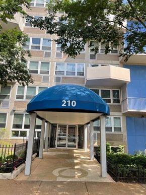 St. Louis apartment for rent - The entrance to apartment building 210 is covered by a blue awning.