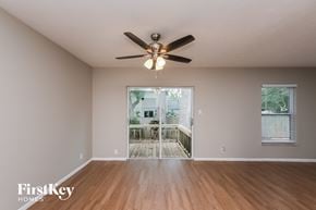Brandon house for rent - an empty living room with a ceiling fan and a deck