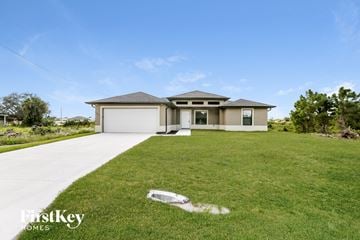 Lehigh Acres house for rent - a house with a lawn and a sidewalk in front of it