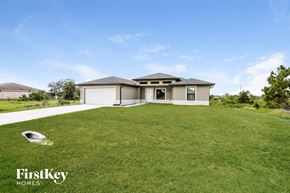 Lehigh Acres house for rent - a home with a large lawn and a garage