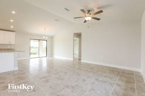Lehigh Acres house for rent - the spacious living room with tile flooring and a ceiling fan