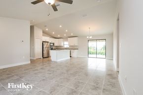Lehigh Acres house for rent - an open kitchen and living room with a ceiling fan