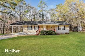 Newnan house for rent - a small yellow house with a porch and a grassy yard
