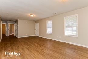 Newnan house for rent - the living room and dining room of an empty house with wood flooring