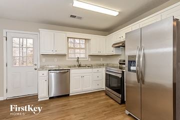 Newnan house for rent - a kitchen with stainless steel appliances and white cabinets