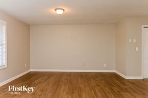 Newnan house for rent - the spacious living room with wood flooring and white walls