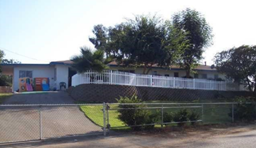 Vista apartment for rent - A white building with a white fence in front of it.