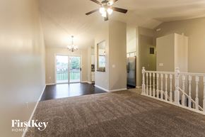 Indianapolis house for rent - an empty living room with a staircase and a ceiling fan