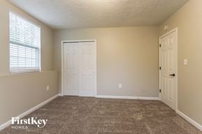 Indianapolis house for rent - a carpeted living room with two doors and a window