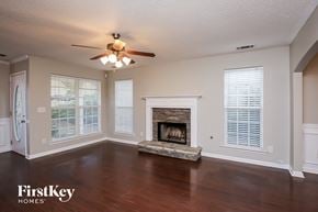 Dawsonville house for rent - a living room with a fireplace and a ceiling fan
