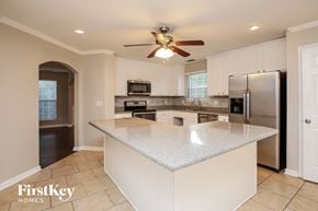Dawsonville house for rent - a white kitchen with a large island and stainless steel appliances