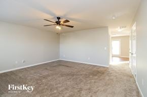 Lexington house for rent - an empty living room with a ceiling fan and carpet