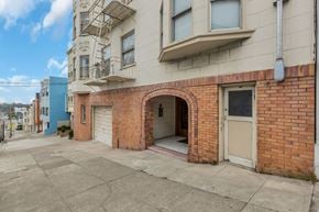 San Francisco apartment for rent - A red brick building with a white door and a balcony.