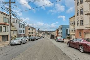 San Francisco apartment for rent - A street with cars parked on both sides and buildings on the sides.