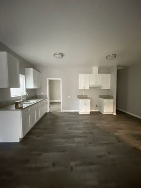 Colton apartment for rent - an empty kitchen with white cabinets and a wooden floor