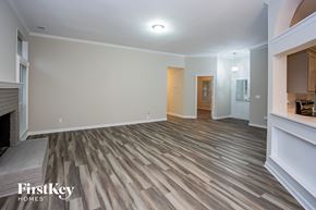 Mint Hill house for rent - A spacious room with wooden flooring and a fireplace on the left side.
