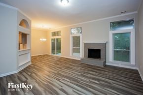Mint Hill house for rent - A spacious living room with a fireplace and wood flooring.