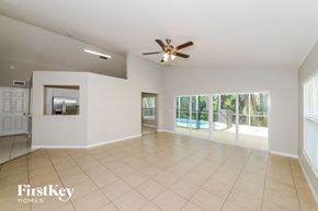 Ellenton house for rent - A spacious room with a ceiling fan and sliding glass doors leading to a balcony.
