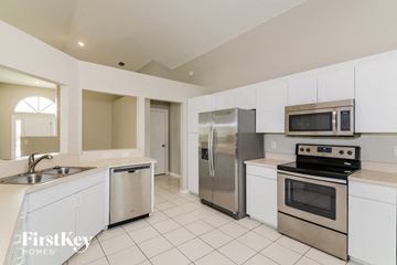 Ellenton house for rent - A kitchen with white cabinets and stainless steel appliances.