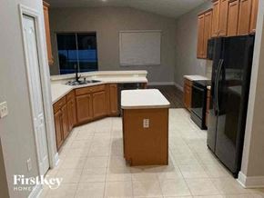 Wesley Chapel house for rent - A kitchen with a black fridge and wooden cabinets.