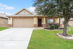 Haslet house for rent - A house with a garage and a tree in front.