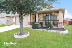 Haslet house for rent - A tree in a circle of dirt stands in front of a house.