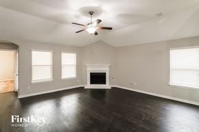 Haslet house for rent - A spacious room with a fireplace and a ceiling fan.