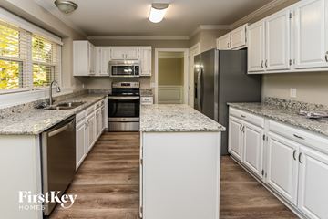 Charlotte house for rent - a kitchen with white cabinets and granite counter tops