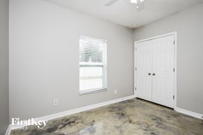 Kissimmee house for rent - a bedroom with a white door and a window and a carpeted floor