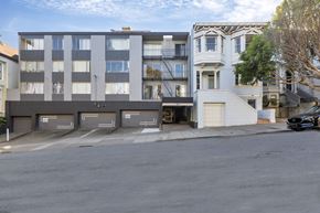 San Francisco apartment for rent - A black car is parked on the street in front of a white garage door.