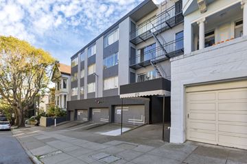 San Francisco apartment for rent - A modern apartment building with a garage door and a tree in front.
