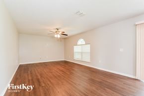 Apopka house for rent - a spacious living room with hardwood floors and a ceiling fan