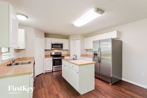 Apopka house for rent - a kitchen with white cabinets and a stainless steel refrigerator